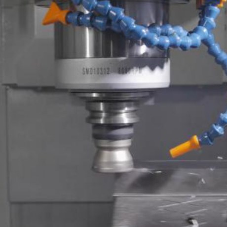 Close-up of a BT40 spindle and cutting tool at work with a blue coolant hose beside it